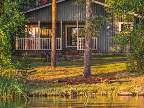 eine Hütte am Wasser mit Bäumen davor in der Unterkunft Holiday Home Hauki by Interhome in Hiukkajoki