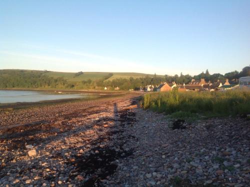 a rocky beach with a town in the background at The Factor's House in Cromarty