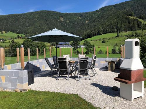 a patio with a table and chairs and an umbrella at Apartment Ferienwohnung Gurkhof 1 - Nockhaus by Interhome in Gnesau