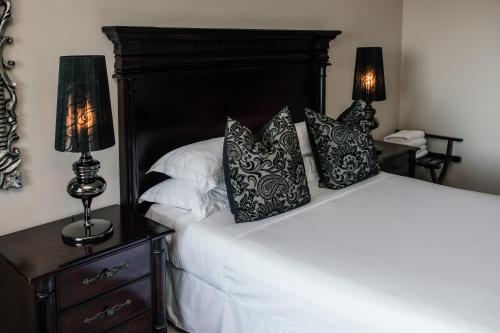a bedroom with a bed with two lamps on a night stand at The View Boutique Hotel & Spa in Amanzimtoti