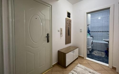 a bathroom with a door leading to a toilet at Apartman Central in Bijeljina