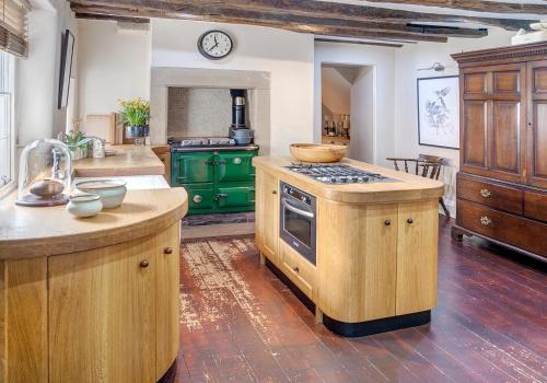 uma cozinha com armários verdes e um fogão forno superior em The Candlemakers em Hexham
