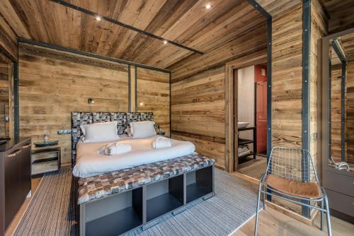 een slaapkamer met een bed en een houten muur bij Chalet Carte Blanche Monts in Tignes