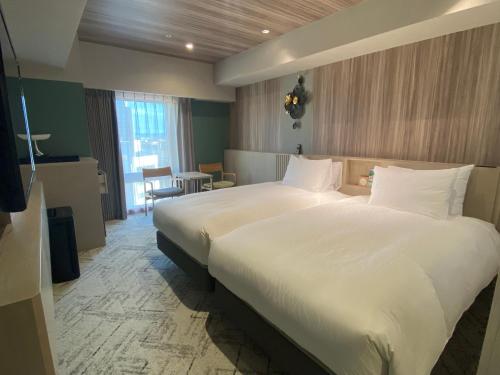 a large white bed in a hotel room at Richmond Hotel Morioka Ekimae in Morioka