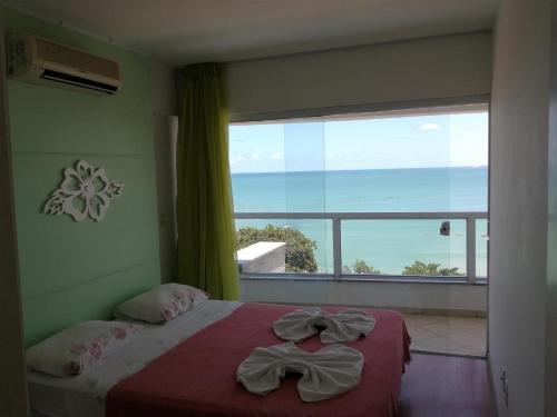 a bedroom with a bed and a large window at Apart Hotel Margherita in Natal