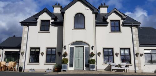 a white house with a blue door at Relax at Safe Haven in Carlingford