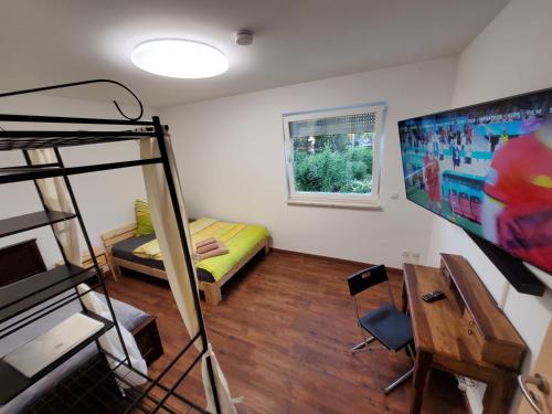 a bedroom with a bunk bed and a bedroom with a tv at Ferienwohnungen Im Grund 22, 22a, 22c Birkenstein in Hoppegarten