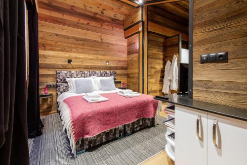 a bedroom with a bed in a room with wooden walls at Chalet Merveilles by Les Etincelles in Tignes
