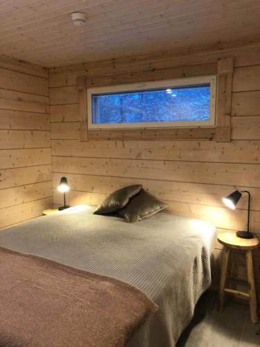 um quarto com uma cama num chalé de madeira em Rokovan Helmi - Natural peace in Ruka-Kuusamo em Ruka