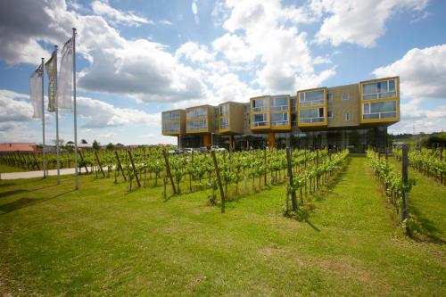 a building with a bunch of windows and vines at LOISIUM Wine & Spa Hotel Langenlois in Langenlois