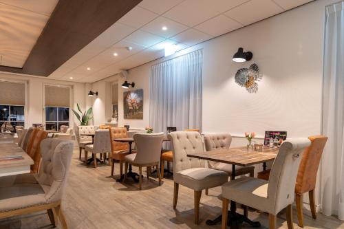 ein Restaurant mit Tischen und Stühlen in einem Zimmer in der Unterkunft Hotel Restaurant "Molenzicht" in Nes