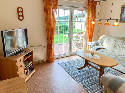 a living room with a couch and a tv and a table at Apartment Osterkamp by Interhome in Eversmeer