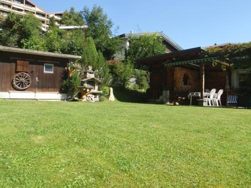a yard with a house and a lawn with at Apartment Schwalbe by Interhome in Adelboden