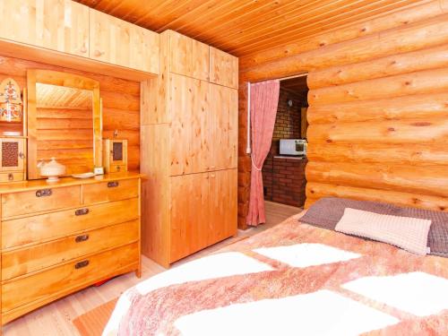 a bedroom with a bed and a wooden wall at Holiday Home Suvituuli by Interhome in Liperi