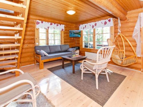- un salon avec un canapé et des chaises dans une cabine dans l'établissement Holiday Home Suvituuli by Interhome, à Liperi