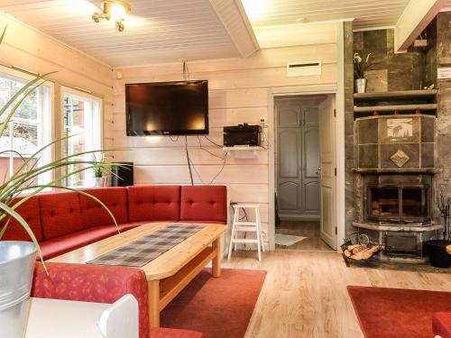 a living room with a red couch and a fireplace at Holiday Home Porukka 1 by Interhome in Sirkka