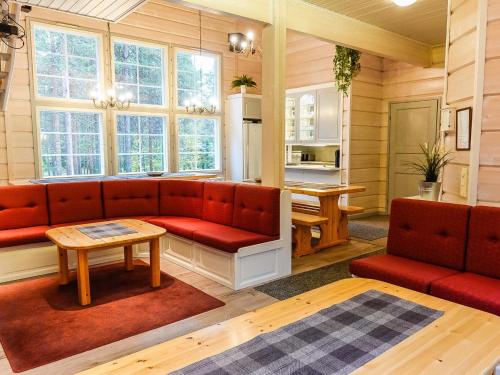 a living room with red couches and a table at Holiday Home Porukka 1 by Interhome in Sirkka