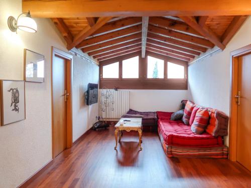 a living room with a red couch and a table at Holiday Home Villa Massimo by Interhome in Carlazzo