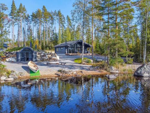 a cabin in the woods next to a body of water at Holiday Home Aurinkoranta by Interhome in Padasjoki