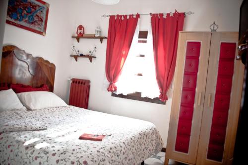 a bedroom with a bed and a window with red curtains at B&b Parco Alta Murgia in Cassano delle Murge