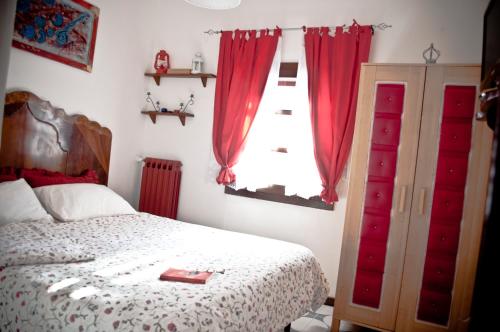 - une chambre avec un lit et une fenêtre avec des rideaux rouges dans l'établissement B&b Parco Alta Murgia, à Cassano delle Murge