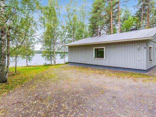 ein weißes Gebäude mit einer Einfahrt neben einem Wasserkörper in der Unterkunft Holiday Home Muikku by Interhome in Hiukkajoki