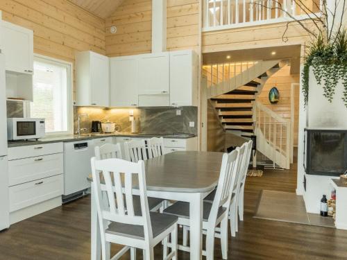 uma cozinha com armários brancos e uma mesa e cadeiras em Holiday Home Aurora by Interhome em Narkaus