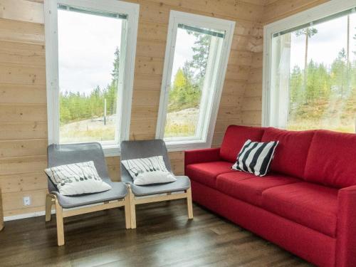 a red couch and two chairs in a room with windows at Holiday Home Aurora by Interhome in Narkaus