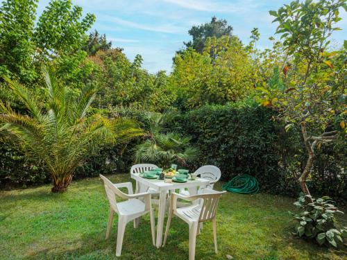 un tavolo bianco e sedie in giardino di Apartment La Rocchetta by Interhome a Marina di Pietrasanta