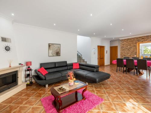 sala de estar con sofá negro y chimenea en Holiday Home Joaquim by Interhome en Estói