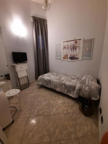 Schlafzimmer mit einem Bett, einem Tisch und einem TV in der Unterkunft B&B L'annunziata in Bari