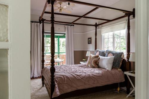 Mount Glorious的住宿－Maiala Park Lodge，卧室配有带枕头的天蓬床