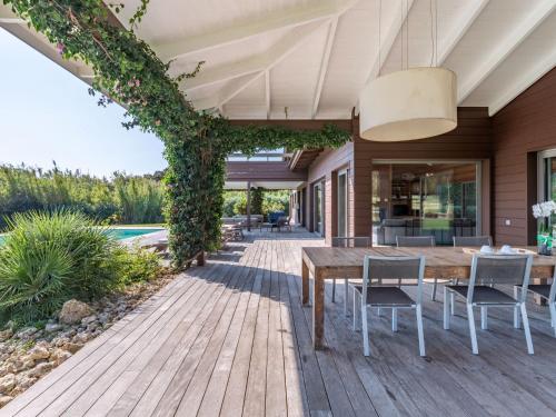 an outdoor deck with a wooden table and chairs at Holiday Home Villa Lavezzi by Interhome in Bonifacio