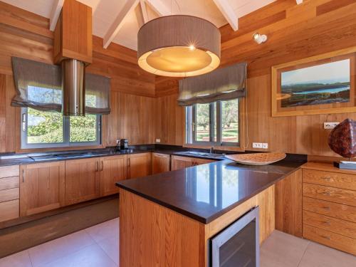 une cuisine avec des armoires en bois et un comptoir noir dans l'établissement Holiday Home Villa Lavezzi by Interhome, à Bonifacio