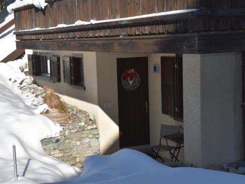 a building with a door with snow on it at Apartment Am Sonnenhang by Interhome in Churwalden