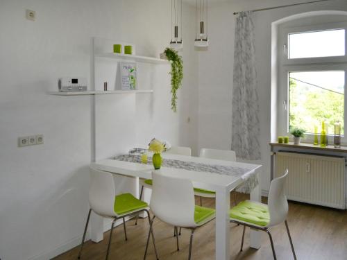 een witte eetkamer met een witte tafel en stoelen bij Apartment Am Rotenberg by Interhome in Detmold