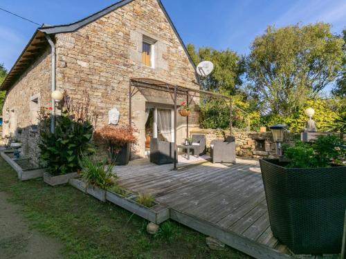 une terrasse en bois devant un bâtiment en briques dans l'établissement Holiday Home Ti Bonheur by Interhome, à Saint-Frégant