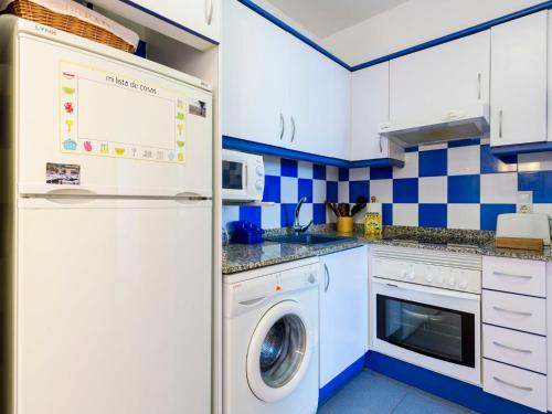 eine blau-weiße Küche mit einer Waschmaschine in der Unterkunft Apartment Mar de Oropesa II - Playa Concha-1 by Interhome in Oropesa del Mar