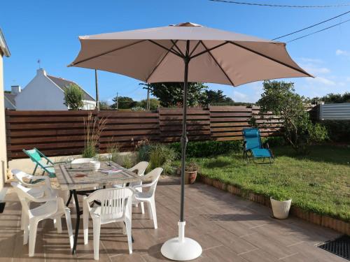 - une table et des chaises avec un parasol sur la terrasse dans l'établissement Holiday Home Les Dunes by Interhome, à Saint-Pabu