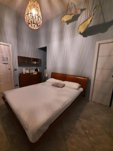 Un dormitorio con una gran cama blanca y una lámpara de araña. en B&B L'annunziata, en Bari