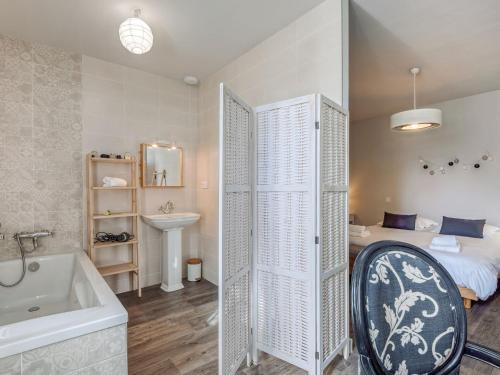 La salle de bains est pourvue d'une baignoire, d'un lit et d'un lavabo. dans l'établissement Holiday Home Villa Ménec by Interhome, à Carnac