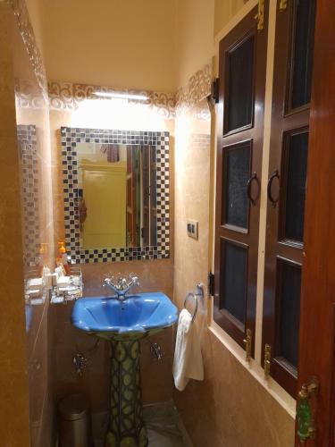 a bathroom with a blue sink and a mirror at Raj Rajeshwari Haveli in Jaipur