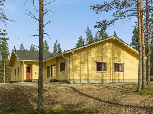une maison jaune avec des arbres devant elle dans l'établissement Holiday Home Sallan saaga by Interhome, à Tikkala