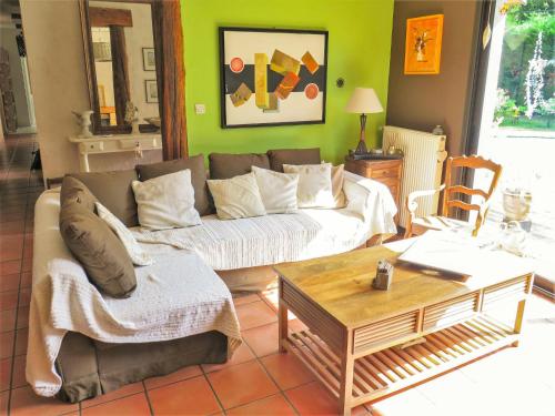 ein Wohnzimmer mit einem Sofa und einem Tisch in der Unterkunft Holiday Home Taste Rebire by Interhome in Vendays-Montalivet