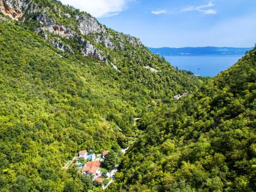 a view of a mountain with a house in the middle at Holiday Home Karin by Interhome in Lovran