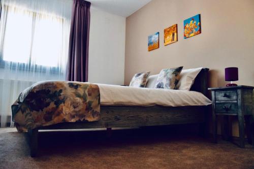 a large bed in a bedroom with a window at CASA ANKELI in Buşteni