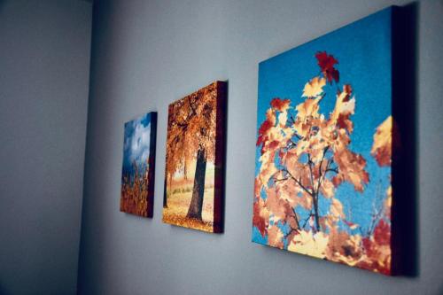 three paintings of a tree on a wall at CASA ANKELI in Buşteni