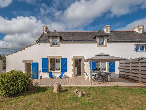 a large white house with a table and an umbrella at Holiday Home Les palmiers by Interhome in Saint-Philibert