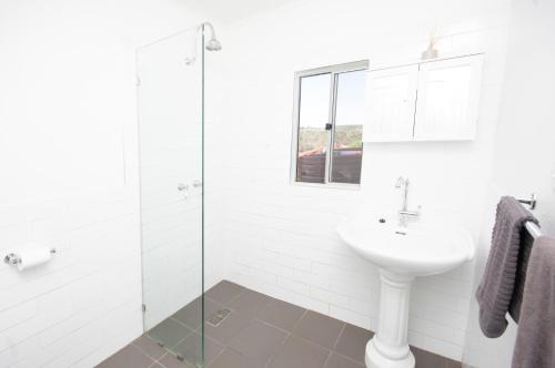 baño blanco con lavabo y ducha acristalada en Private Peaceful Country Homestead - Frankland River Retreat, en Frankland
