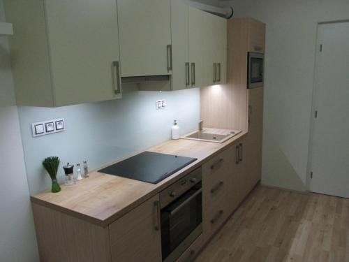 a kitchen with white cabinets and a wooden counter top at Apartmán Cardovi in Dolní Morava
